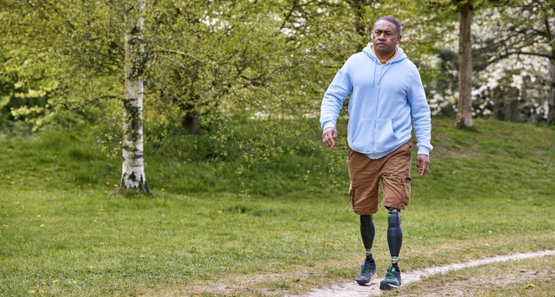 Man walking with two prosthetic legs
